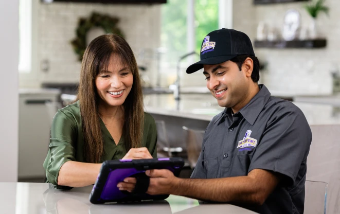 Three employees standing in front of a blue and yellow service van.