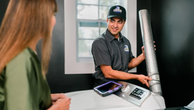 Dryer Vent Wizard tech discussing pipe with customer.