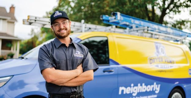 A service worker stands in front of a yellow and blue van.