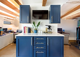 A hall with cupboards, books, and a television.