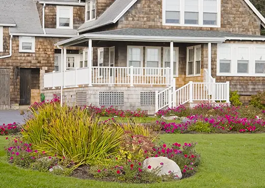 Flower beds in front of charming two story home.