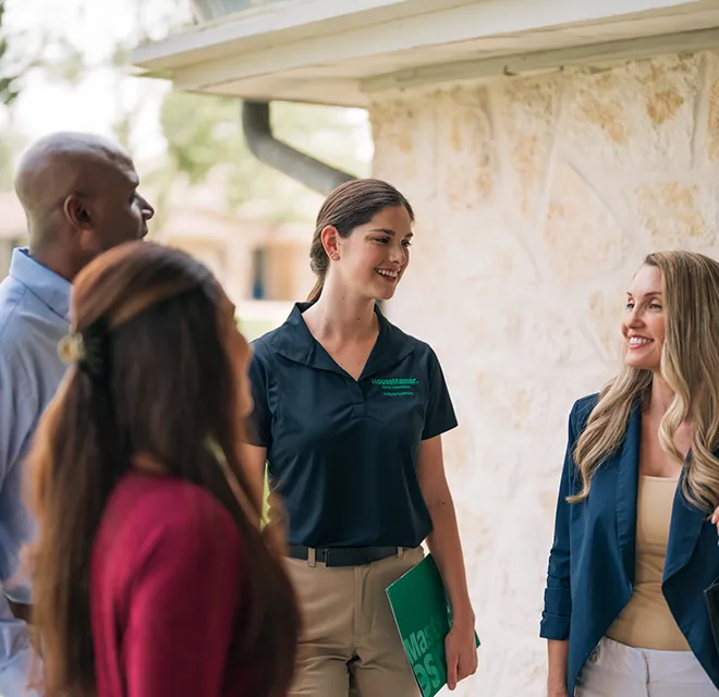 An HMS inspector speaking with a group of people on a home porch.