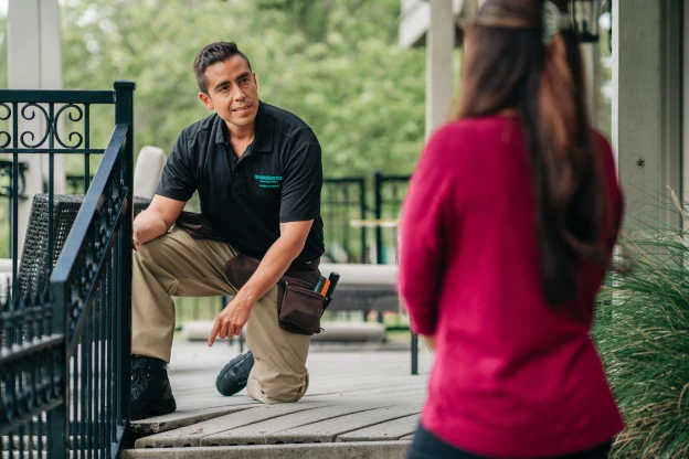 Female HouseMaster inspector leaning on branded vehicle.