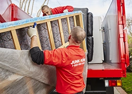 Juk employees carrying a mattress to the truck.