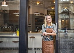 Woman standing beside a glass door.