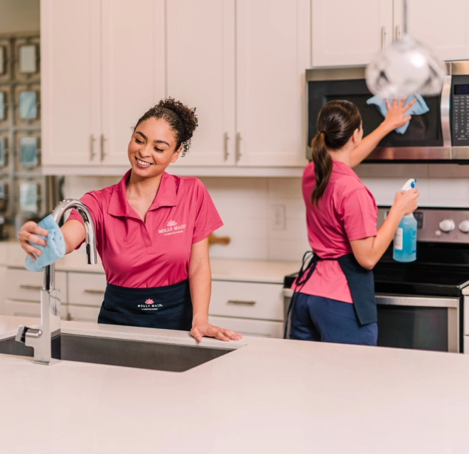 Two MLY service workers cleaning a kitchen.