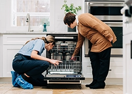 Mr. Appliance employee discussing with a woman in a kitchen.