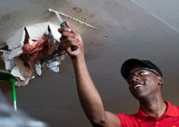 MRH employee repairing a ceiling inside a home.