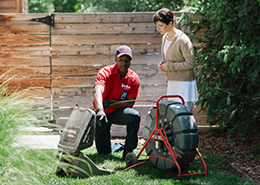 Mr. Rooter plumber and client viewed from a ground-level camera.