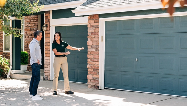 A PDS worker speaks with a person while standing outside the home.