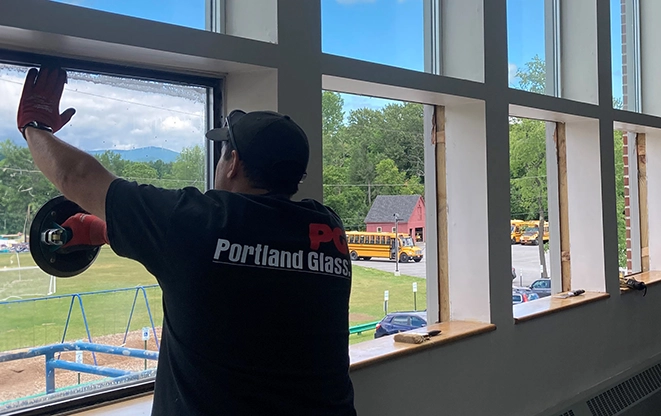 A worker from Portland Glass installs a window.