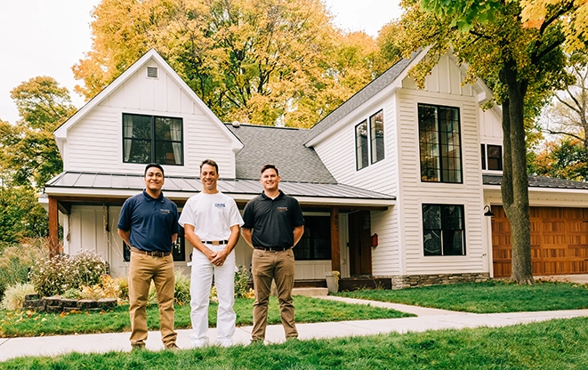 Row of smiling associates standing outdoors.