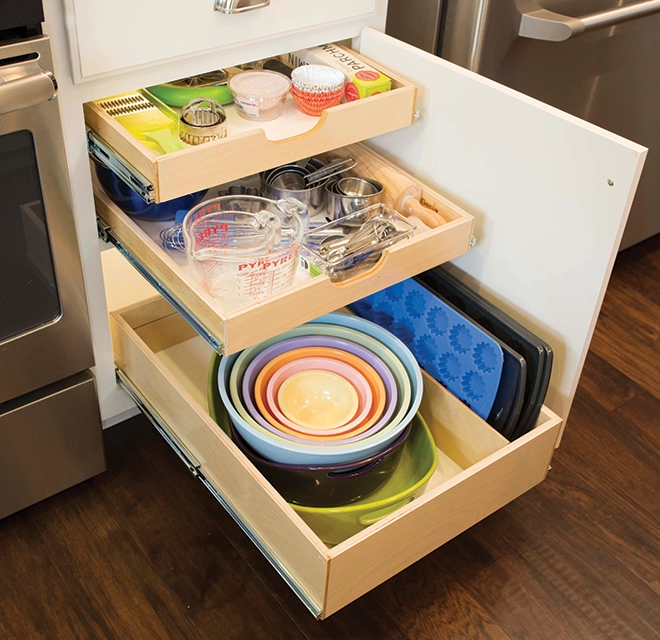 Pots and pans arranged inside a kitchen cabinet.