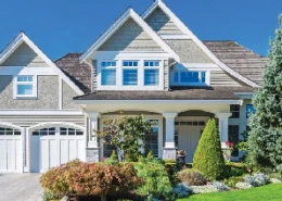 A spacious house with a landscaped garden in front.