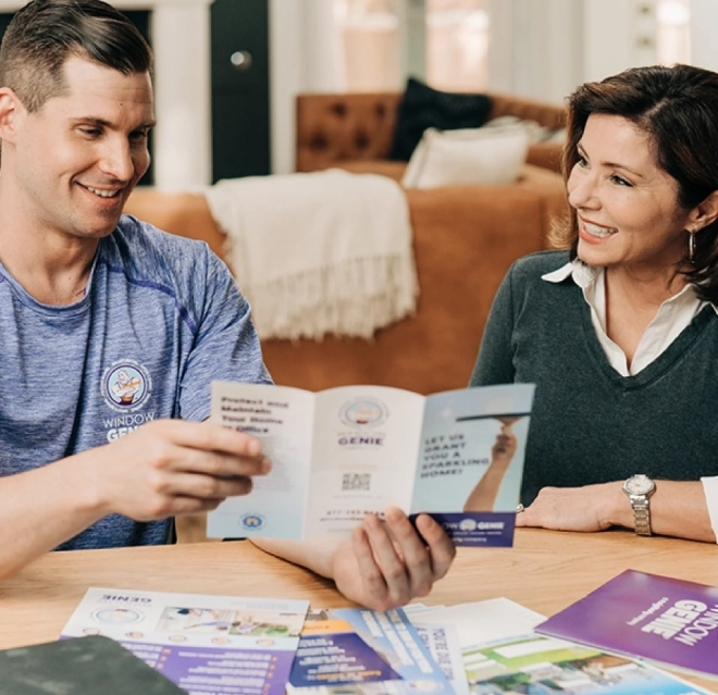 Window Genie worker showing a brochure to a woman.