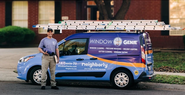 A technician standing near a window geine van.