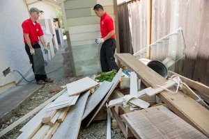 Junk King employees removing wood strips and glass debris.