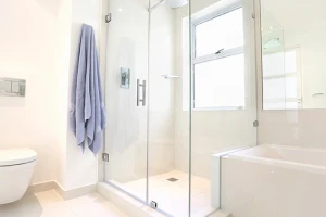 White bathroom with large glass shower.