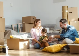 Family surrounded by boxes, moving in to new home.