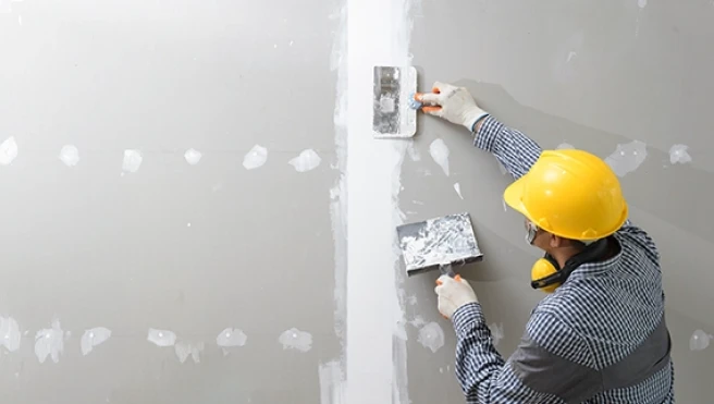 Employee repairing a drywall.