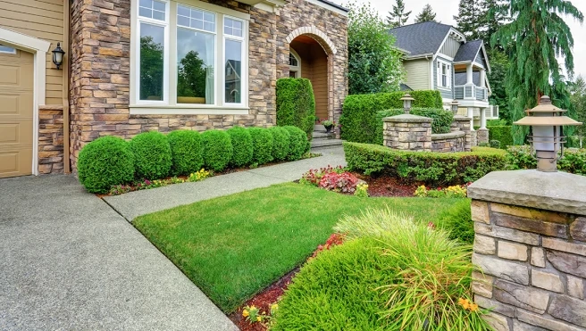 Stone-front home with neatly landscaped yard.
