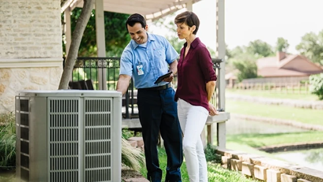AireServ tech discussing air conditioner with female customer.