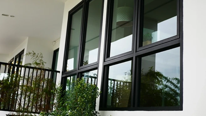 Modern black-framed windows line a white exterior wall.