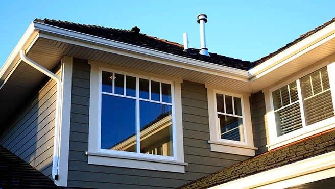 Close-up of a modern house corner featuring large windows.