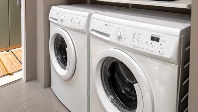 A stacked white washing machine and dryer unit.