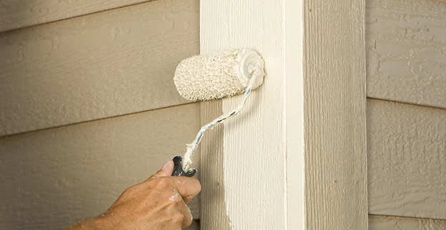 FSP Employee painting wooden wall.