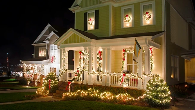 A charming house decorated with festive lights and wreaths.