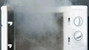 Overheating microwave with smoke coming out of it