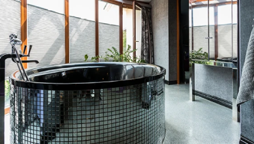 glass tiled soaking tub in modern bathroom