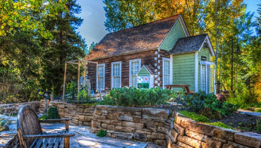 tiny log home with low stone wall