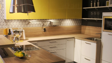Modern yellow and white kitchen with undercabinet lighting.