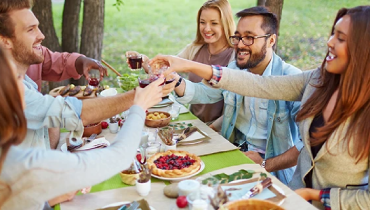 five friends toasting while dining outside