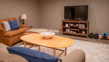Finished basement with furniture and TV.