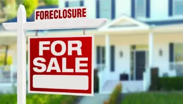 Foreclosure for sale sign in front of a house