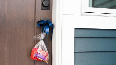 Bag of candy hanging from a doorknob.