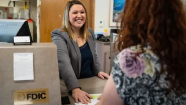 Smiling bank associate with customer.