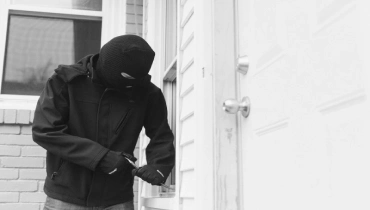 Burglar trying to pick a lock to break into a home