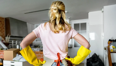 Women wearing cleaning gloves observing what she needs to clean