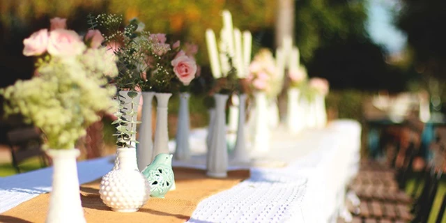 outdoor dinner table decorated with flowers and vases