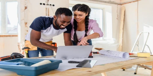 Young African American couple working on laptop during home renovation project