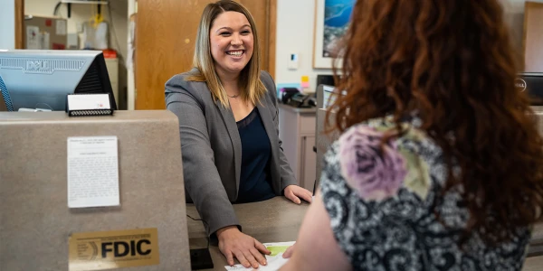 Smiling bank associate with customer