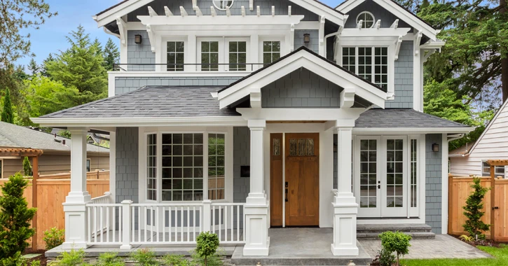 Craftsman style house with grey shaker siding and white accents