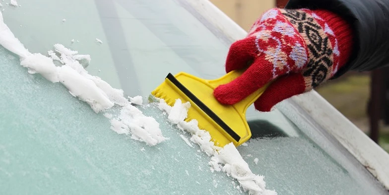 Scraping ice off a car windshield