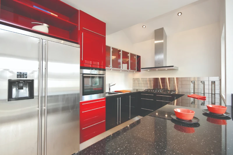 Modern kitchen with red cabinets and stainless steel refrigerator