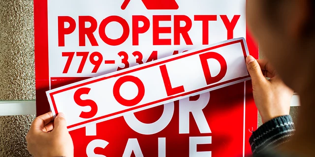 red and white property sold sign