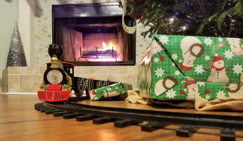 Christmas presents and train on floor under tree